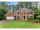 Traditional brick home with symmetrical design, well-manicured lawn, and mature trees at 739 Dushea Nw Ct, Kennesaw, GA 30144