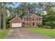 Classic brick home with a well-manicured lawn, attached garage, and symmetrical window design at 739 Dushea Nw Ct, Kennesaw, GA 30144
