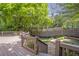 Multi-level wood deck leads to the stone patio and is surrounded by lush landscaping and a privacy fence at 1064 Saint James Xing, Brookhaven, GA 30319