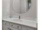 This bathroom features a modern round mirror and updated vanity with marble countertop at 1064 Saint James Xing, Brookhaven, GA 30319