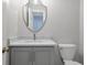 Stylish half bathroom featuring marble countertop and a unique, shield-shaped mirror at 1064 Saint James Xing, Brookhaven, GA 30319