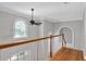 Bright hallway with hardwood floors, arched window, and white banister and railings at 1064 Saint James Xing, Brookhaven, GA 30319