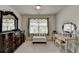 Stylish bedroom featuring classic furniture, a plush bench, and a well-lit vanity area at 1200 Bar Harbor Pl, Lawrenceville, GA 30044