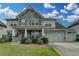 Charming two-story home featuring stone accents, a three-car garage, and beautifully landscaped front yard at 1200 Bar Harbor Pl, Lawrenceville, GA 30044