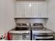 Laundry room featuring front load washer and dryer with storage cabinets above at 1200 Bar Harbor Pl, Lawrenceville, GA 30044