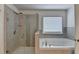 Modern bathroom featuring a glass-enclosed shower and soaking tub for ultimate relaxation and convenience at 1200 Bar Harbor Pl, Lawrenceville, GA 30044