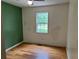 Bedroom featuring hardwood floors, ceiling fan, and green accent wall at 279 Fairview Dr, Dallas, GA 30157