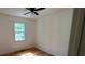 Bright bedroom with hardwood flooring, ceiling fan, and a window overlooking lush greenery at 279 Fairview Dr, Dallas, GA 30157