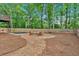 Expansive backyard with a play area, fire pit, and a hammock surrounded by mature trees at 4053 Five Oaks Ct, Powder Springs, GA 30127