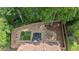 Aerial view of a private backyard with a turf area, fire pit, and wooded surroundings at 4053 Five Oaks Ct, Powder Springs, GA 30127