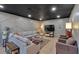 Well-lit basement living space with sectional sofa, entertainment center, and stylish accents at 4053 Five Oaks Ct, Powder Springs, GA 30127