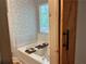 Bathroom featuring a soaking tub, wooden sliding door and decorative wall paper at 4053 Five Oaks Ct, Powder Springs, GA 30127