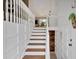 Bright entryway with wooden stairs and white wainscoting leading to a dining area at 4053 Five Oaks Ct, Powder Springs, GA 30127