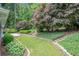 Well-manicured backyard featuring a stone retaining wall and mature trees at 703 Kirkwood Cir, Woodstock, GA 30189
