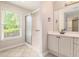 Bright bathroom with a glass-enclosed shower, a large window with shades, and a single sink vanity at 703 Kirkwood Cir, Woodstock, GA 30189