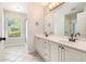 Bright bathroom features a double vanity, neutral tiling, and a large window bringing in natural light at 703 Kirkwood Cir, Woodstock, GA 30189