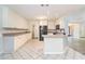 Open kitchen with stainless appliances, white cabinetry, and modern fixtures at 703 Kirkwood Cir, Woodstock, GA 30189
