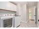 Laundry room featuring a washer, dryer, tile flooring, cabinets and view to hallway at 703 Kirkwood Cir, Woodstock, GA 30189