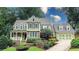 Attractive two-story home featuring green siding, brick accents, and meticulously maintained landscaping under a blue sky at 192 Chicopee Dr, Marietta, GA 30060