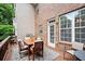 Back deck with an outdoor dining set, surrounded by greenery and a brick house exterior at 2303 Waters Edge Trl, Roswell, GA 30075