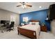 Spacious bedroom with a desk, blue accent wall, and ceiling fan, offering a blend of rest and productivity at 2303 Waters Edge Trl, Roswell, GA 30075