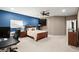 Comfortable bedroom with blue accent wall, ceiling fan, and desk area for a functional and inviting space at 2303 Waters Edge Trl, Roswell, GA 30075