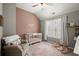 Bright Bedroom with decorative wall, crib, comfortable chair, and shuttered windows at 2303 Waters Edge Trl, Roswell, GA 30075