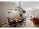 Inviting dining area with wood floors, modern chandelier, and open layout to living room at 2303 Waters Edge Trl, Roswell, GA 30075
