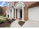 Inviting doorway with brick arch, white columns, and manicured landscaping at 2303 Waters Edge Trl, Roswell, GA 30075