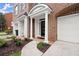 Inviting entryway with brick archway, white columns, and adjacent garage entrance at 2303 Waters Edge Trl, Roswell, GA 30075