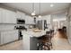 Modern kitchen featuring white cabinets, stainless steel appliances, granite countertops, and an island with bar stools at 2303 Waters Edge Trl, Roswell, GA 30075