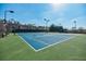 Well-maintained tennis court with lighting and surrounding trees, perfect for evening games at 2303 Waters Edge Trl, Roswell, GA 30075