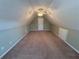 Attic space featuring carpeted floor, ceiling fan, and a closed white door at 3426 Olivia Grace Way, Dacula, GA 30019