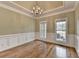 Dining room featuring hardwood floors, decorative trim, tray ceilings, and a chandelier fixture at 3426 Olivia Grace Way, Dacula, GA 30019