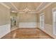 Charming dining room with hardwood floors, a tray ceiling, chandelier, and adjacent laundry room at 3426 Olivia Grace Way, Dacula, GA 30019