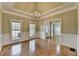 Dining room with hardwood floors, a tray ceiling, decorative trim, and a chandelier at 3426 Olivia Grace Way, Dacula, GA 30019