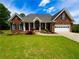 Charming brick home with a well-manicured lawn, attached garage, and inviting front porch at 3426 Olivia Grace Way, Dacula, GA 30019
