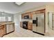 Kitchen featuring a stainless steel refrigerator, black gas range, and wood cabinetry at 3426 Olivia Grace Way, Dacula, GA 30019