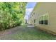 Side view of a spacious backyard with healthy lawn, complemented by mature trees providing shade and privacy at 6285 Polar Fox Ct, Riverdale, GA 30296