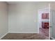 Neutral-colored bedroom with a doorway to the kitchen and carpeted floors at 6285 Polar Fox Ct, Riverdale, GA 30296