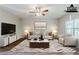 Beautiful staged living room with ceiling fan, large tv and window, and gorgeous modern decor at 6285 Polar Fox Ct, Riverdale, GA 30296