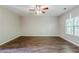 Spacious living room with hardwood-style floors, a ceiling fan, and a large window at 6285 Polar Fox Ct, Riverdale, GA 30296