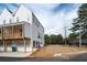 Side view of charming white townhouse with garage, covered porch, and wood fence at 101 Pearl St, Woodstock, GA 30188