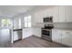 Open kitchen with stainless steel appliances, hardwood floors, and abundant storage space at 101 Pearl St, Woodstock, GA 30188