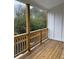 An outdoor porch with wooden floors, railings, and a view of the surrounding trees at 101 Pearl St, Woodstock, GA 30188