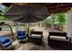 Inviting covered patio with comfortable seating and an umbrella providing shade for outdoor enjoyment at 1220 Wade Green Nw Cir, Acworth, GA 30102