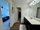 Bathroom with white countertop, dark cabinets, shelving unit, and view into bedroom at 1606 Larkspur Trl, Conyers, GA 30012