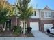 Charming brick townhome with a one-car garage, inviting front yard, and well-maintained landscaping at 1606 Larkspur Trl, Conyers, GA 30012