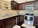 Charming kitchen features stainless steel appliances, granite countertops, and dark wood cabinetry at 1606 Larkspur Trl, Conyers, GA 30012