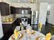 Modern kitchen with dark cabinets, stainless steel appliances, and a dining area with stylish decorations at 1606 Larkspur Trl, Conyers, GA 30012